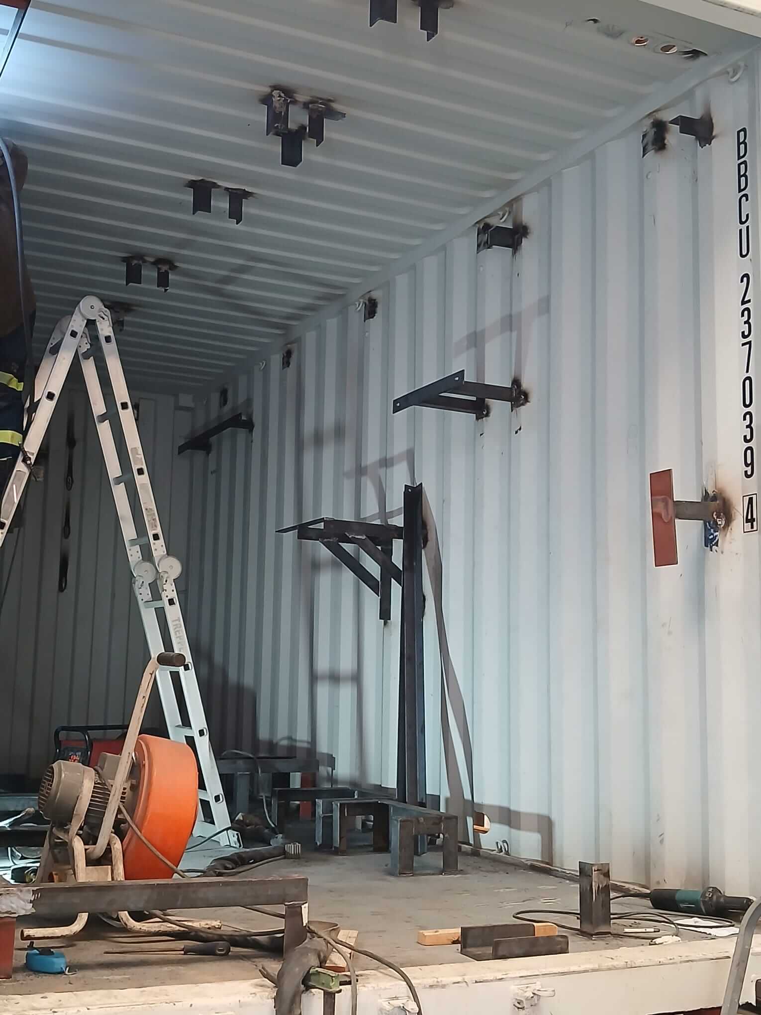 3_ContainerInterior_beginning_3 Metal brackets and support structures being installed on the walls and floor of the POSEIDON container.